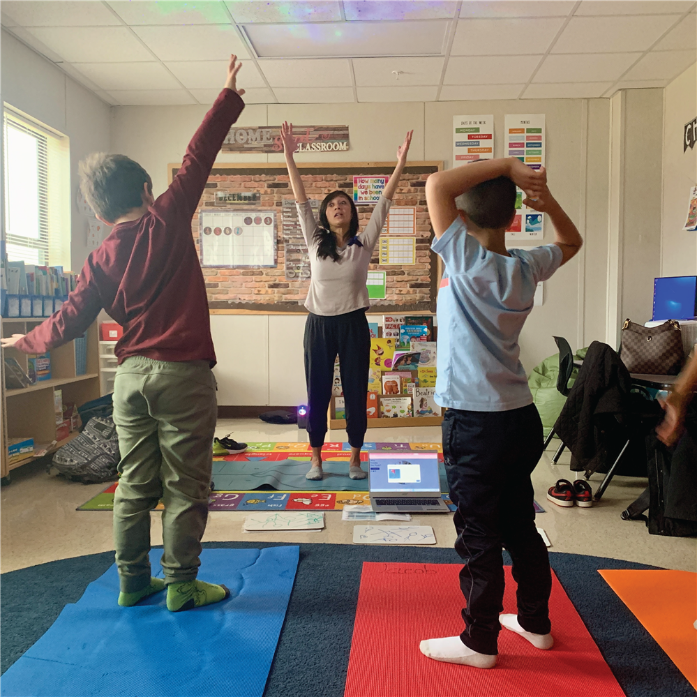 Students doing yoga with Mrs. Grassi